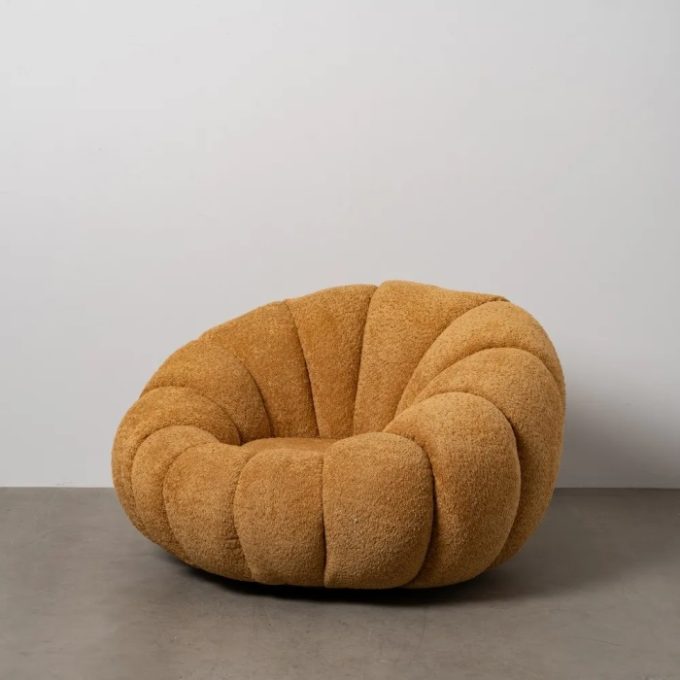sillón redondo con forma de pétalo y tapizado tejido de rizo mostaza estilo art decó